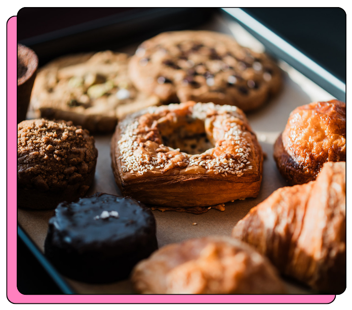 Assorted pastries including croissants and cookies on a baking tray for an event in an office, with coffee catering 