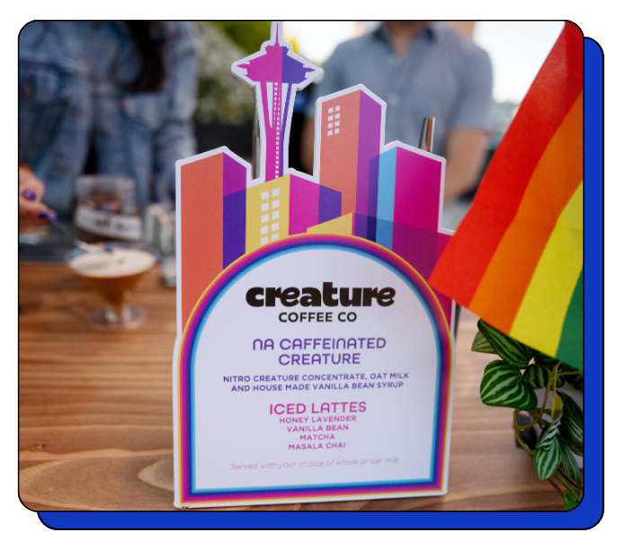 Colorful custom coffee catering menu for Creature Coffee Co with a cityscape design on a table.