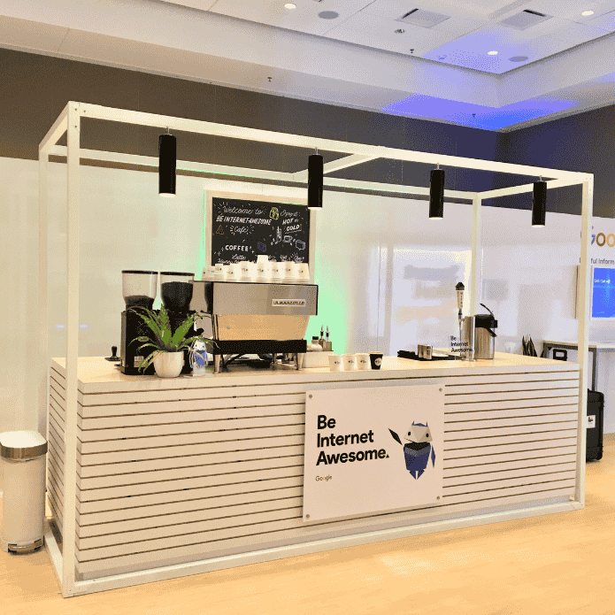 Coffee station with a 'Be Internet Awesome' sign in a modern indoor setting. Custom-branded coffee shop experience for a large corporate event at a hotel.