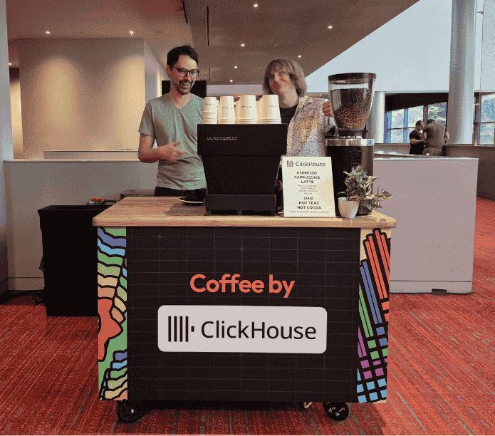 Two people behind a coffee cart with 'Coffee by ClickHouse' branding in an indoor setting.