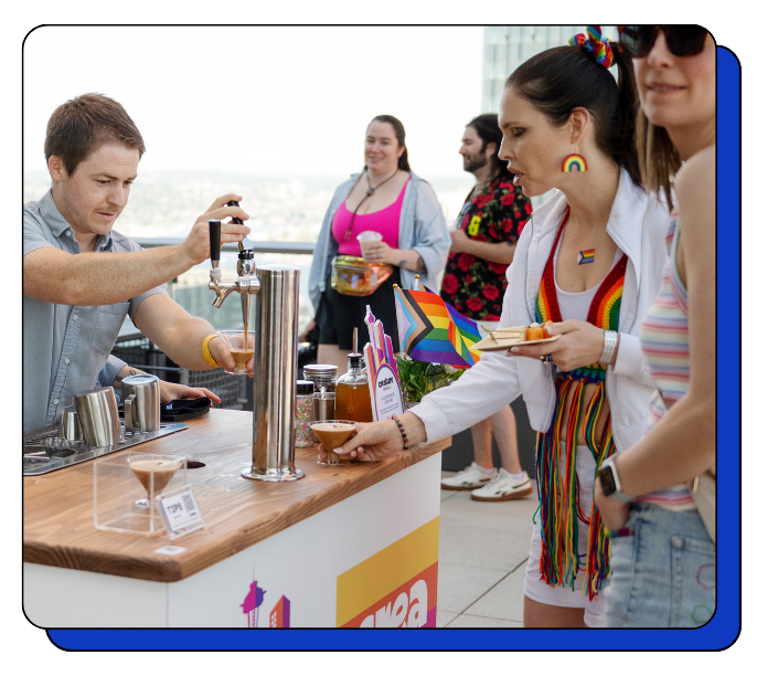 People at a bar with a focus on a barista serving lattes, cold brew, and matcha nitro drinks.
